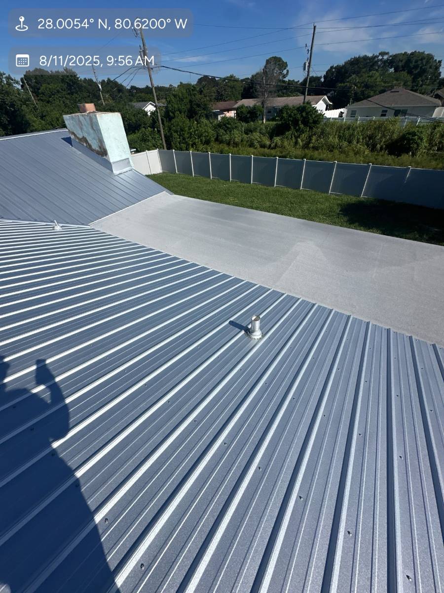 Gray metal roof with a coated flat section by Hippo Roofing in Palm Bay, FL
