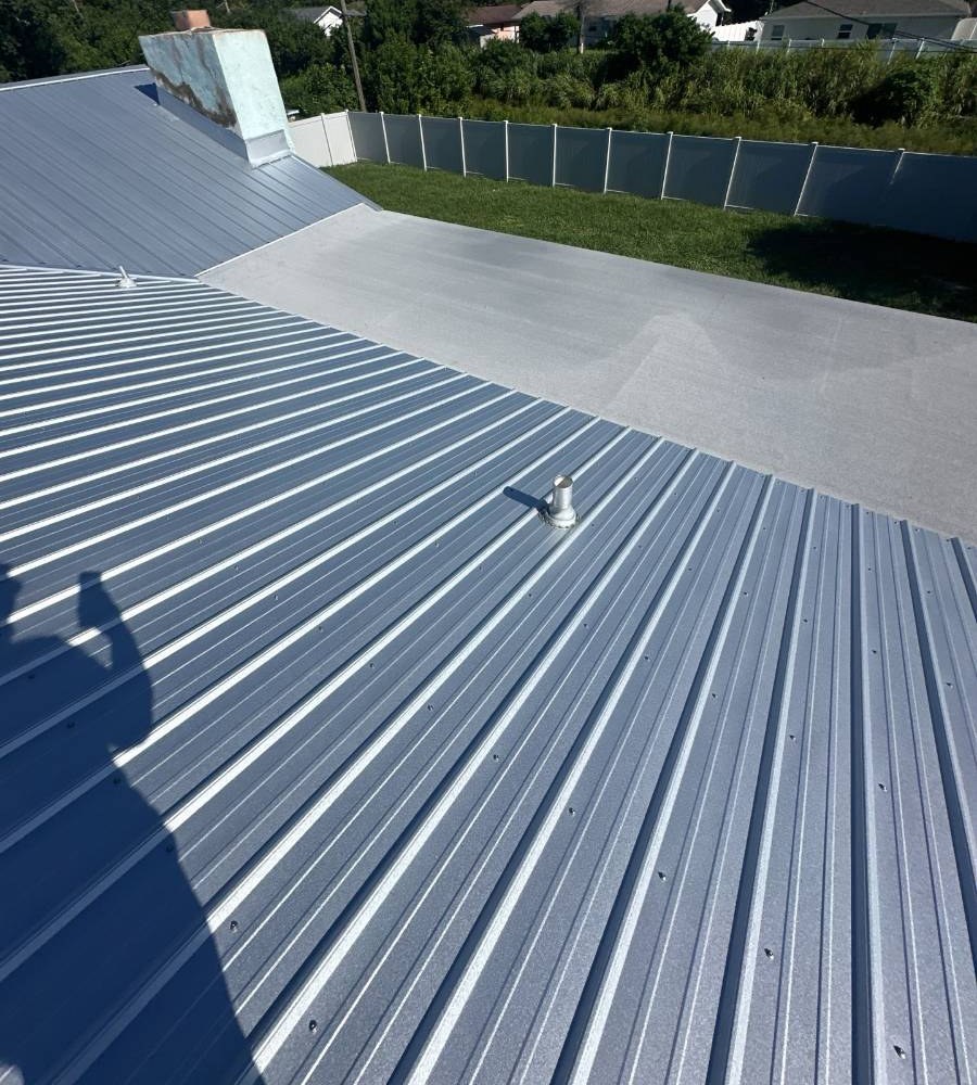 Gray metal roof with a coated flat section by Hippo Roofing in Palm Bay, FL