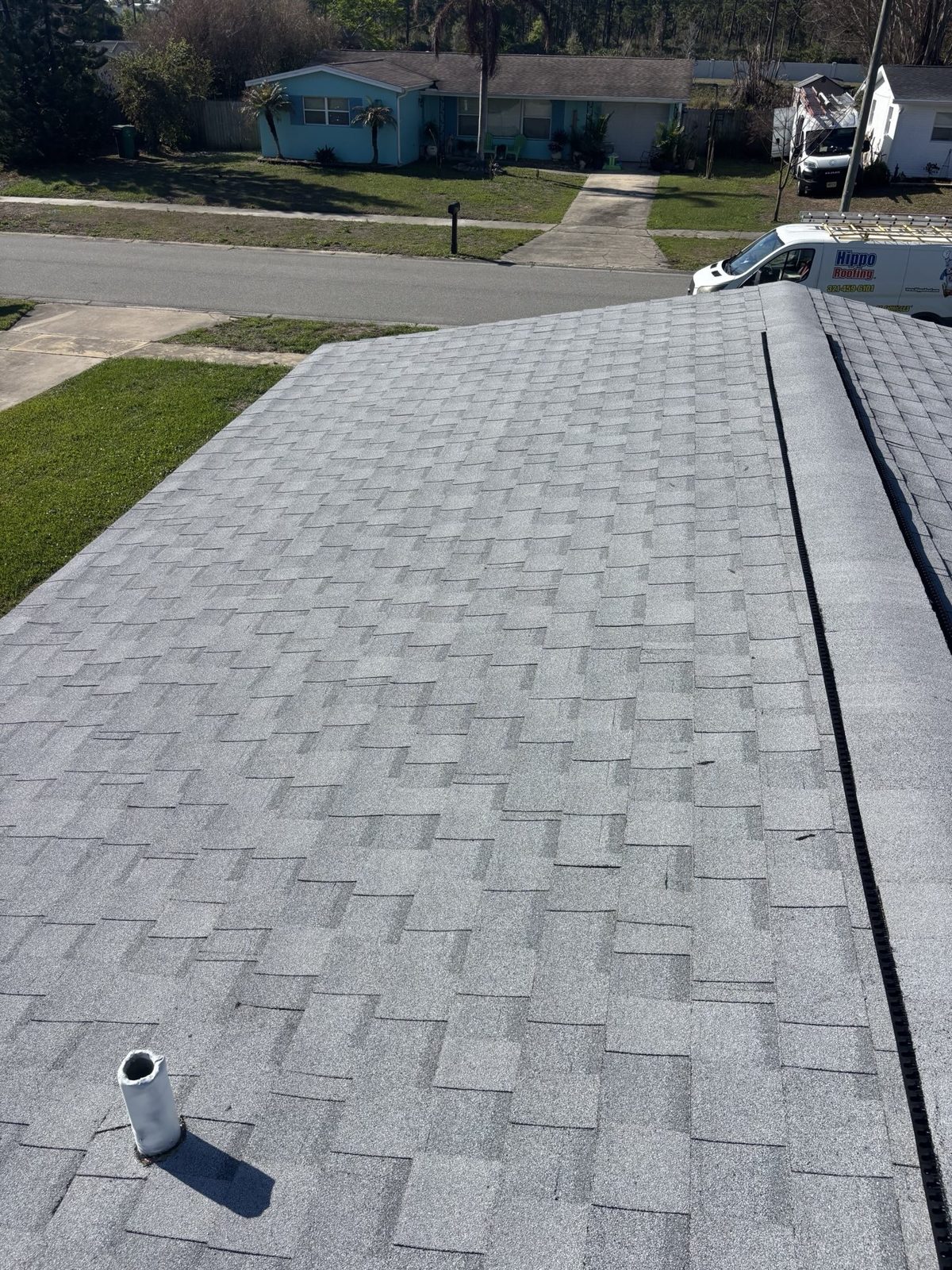 Close-up of the finished shingle roof with a Hippo Roofing service van